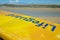 Cornish beach with yellow Lifeguards surfboard diagonally in the frame