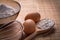 Corolla eggs flour in spoon bowl on wooden board