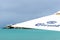 Corona brand/branded beach umbrella with turquoise ocean and stormy clouds in background