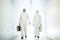 Corona virus concept. Two male scientist doctors in biochemical protective suits walk in laboratory coridor with