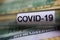 Corona virus covid-19 uncertain consequential costs concept symbol: macro closeup of  blood sample vial on 100 us dollar
