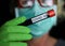 Corona virus diagnostic test concept:  closeup portrait of isolated blonde woman with surgical protection mask and green gloves