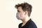 Corona virus. Young guy in a mask on a gray background. Protection against viruses, infections, exhaust fumes