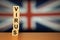 Coronavirus concept background. United Kingdom flag with text VIRUS on wooden cube