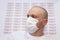 Coronavirus. Convid-19. A sick medical patient wears a face mask with COVID-19 coronavirus text at white background.