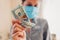 Coronavirus covid-19 pandemic pharmacy profit on medical masks. High prices for medicine. Woman holding dollars cash