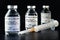 Coronavirus Covid-19 vaccine concept -  three glass vials on black table, hypodermic syringe near closeup detail label own design