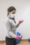 Coronavirus. COVID-19. Young beautiful woman doing sport at home during quarantine with mask protection. Stay at home workout