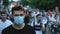 Coronavirus epidemic demonstration masked activist marches in city street crowd.