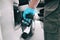 Coronavirus gas oil prices dropping man pumping gasoline at gas station wearing medical blue glove as COVID-19 spreading