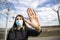 coronavirus global fight - woman wearing surgical mask and airport sign - cancelled flights - travel ban