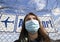 coronavirus global fight - woman wearing surgical mask and airport sign - cancelled flights - travel ban