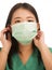 Coronavirus outbreak in China - young beautiful Asian Chinese medicine doctor woman or hospital nurse in scrubs using protective