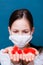 Coronavirus on the palms of a girl in a medical mask. The child looks at the coronavirus. Protecting children from a pandemic