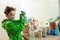 Coronavirus pandemic prevention. A boy wearing gloves and a mask uses a disinfectant liquid to wipe the food package upon delivery