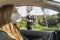 Coronavirus. A police medical technician in full protective gear collects a sample from a young woman sitting inside her car. Coro