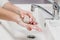 Coronavirus prevention. Wash hands with antibacterial soap and warm running water rubbing nails and fingers in sink. Washing hands