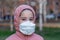 Coronavirus protection. A caucasian girl wearing respirator walking on a street