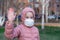 Coronavirus protection. A caucasian girl wearing respirator walking on a street
