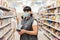 Coronavirus. A salesman in a medical mask poses with an electronic device in the aisle of the store. The concept of protection