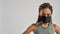 Coronavirus and sport. Confident sportive mixed race woman wearing black medical protective face mask looking at camera