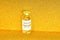 Coronavirus vaccine. Vaccine values during the acute period of the covid-19 pandemic concept. Vial on a golden