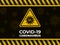 Coronavirus warning yellow sign on a dark abstract background. Danger of infection covid-19 novel bacteria.