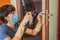 Coronovirus Prevention A man disinfects a doorknob. Closeup of a caucasian man disinfecting the door handle by spraying