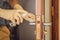 Coronovirus Prevention A man disinfects a doorknob. Closeup of a caucasian man disinfecting the door handle by spraying