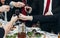 Corporate business man toasting at dinner party table hands close-up, wedding reception guests toast alcohol drinks in glasses