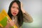 Corporate business stress portrait of young attractive upset and stressed executive Asian Chinese woman tired and unhappy holding