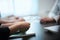 Corporate decision making. A group of businessmen shows and discusses something while colleagues are listening, sitting at a table