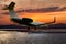 Corporate jet plane on the background of a picturesque sunset on the airport apron