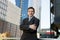 Corporate portrait attractive businessman standing outdoors urban office buildings