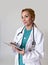 Corporate staff portrait of happy woman md emergency doctor or nurse posing smiling cheerful with stethoscope using digital tablet