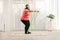 Corpulent woman exercising with a resistance band at home