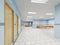 Corridor in the clinic with waiting areas for patients with an office for a doctor in white and blue with orange chairs