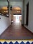 Corridor of elegant colonial Mexican-style construction with a large decorative mirror and chandelier in the background and a wind