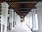 the corridor of a hotel looks beautiful teak wood and charming pillars