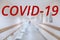 The corridor in thospital is out of focus. The inscription in red covid-19