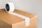 Corrugared brown cardboard box with white adhesive tape