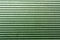 Corrugated green metal plate surface.