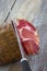 Corsican traditional delicatess coppa sliced with a knife on wooden background