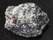 Corundum crystals in gneiss stone on dark