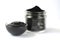 Cosmetic activated carbon charcoal powder in a glass jar and beauty face mask mixture on white with copy space.