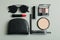 Cosmetic bag, makeup cosmetics and sunglasse on gray background