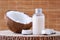 Cosmetic bottle and fresh organic coconut for skincare, natural background