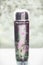 Cosmetic bottle with liquid and little pink flowers. Floral essence, herbal extract toner or perfume on table, front view. Beauty