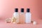 Cosmetic bottles on a background with color of live coral. Composition of shampoo, conditioner and body lotion bottles.