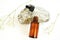 Cosmetic bottles with pipette with essential oil in different jars, natural stone and flowers on a white background. Alternative